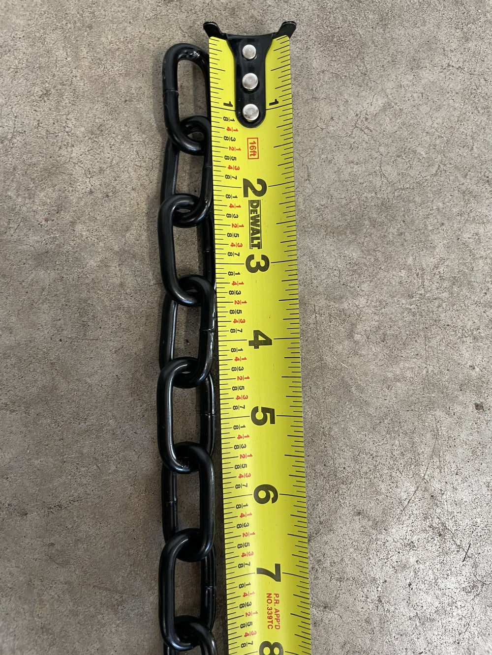 3/16 inch black heavy-duty chain beside a tape measure, about 1.1 inches per link