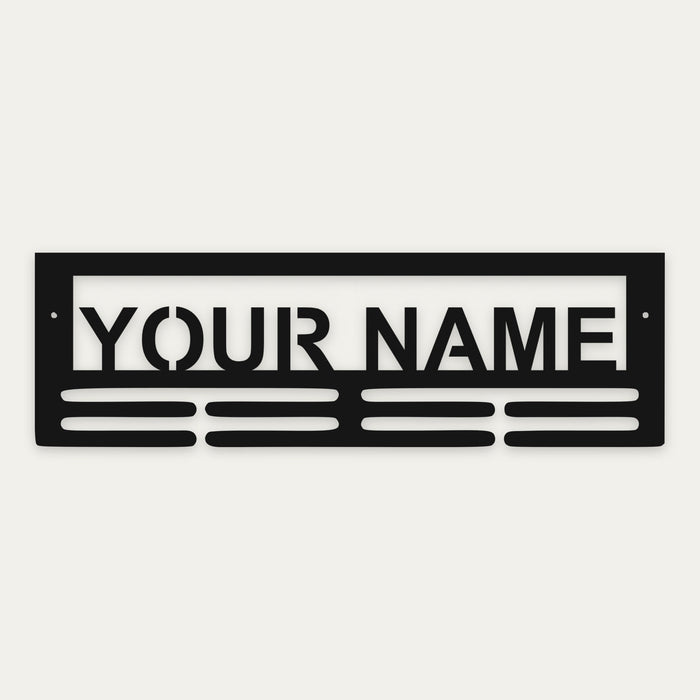 Personalized metal medal hanger in black steel with YOUR NAME cut into the top panel and 8 ribbon slots below